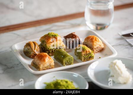 Teller frischer türkischer Baklava auf einem Tisch im Restaurant Karaköy Güllüoğlu in Beyoğlu, Istanbul, Türkei. Stockfoto