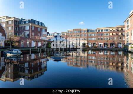 Reflexionen des Wohnblocks im Hafenwasser im Voorhaven-Viertel im Zentrum von Sassenheim, Südholland in den Niederlanden Stockfoto