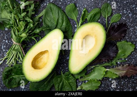 Reife Avocados mit einer Mischung aus Bio-Grünzeug sind die perfekten Zutaten für eine rohe, paläoartige und gesunde Ernährung. Stockfoto