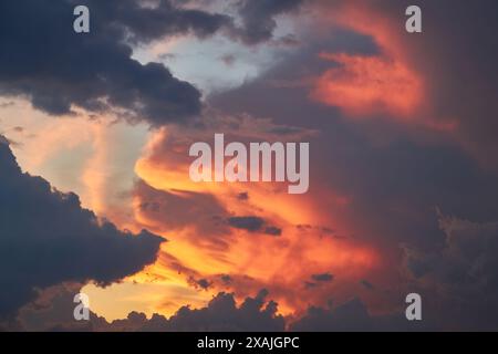 Ein faszinierendes Fragment des Himmels, eine natürliche Kulisse mit bunten Wolken mit faszinierenden Formen, die von der untergehenden Sonne beleuchtet werden, schaffen einen Stockfoto