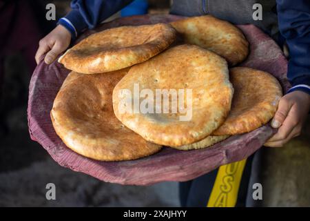 Eine Person hält ein Tablett mit Brot Stockfoto