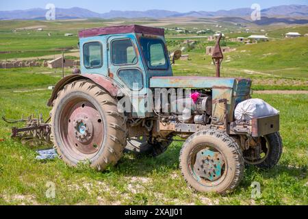 Ein alter, rostiger Traktor sitzt auf einem Feld Stockfoto