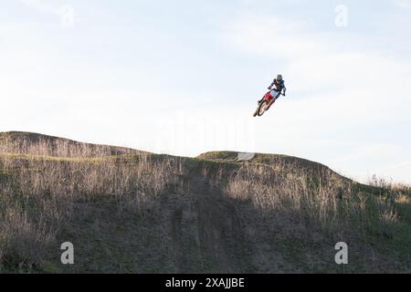 Ein erfahrener Motocross springt auf dem Trail mit dem Fahrrad. Stockfoto