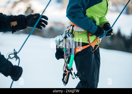 Kletterer, die sich auf einen Eisklettern mit Gurten und Seilen vorbereiten Stockfoto