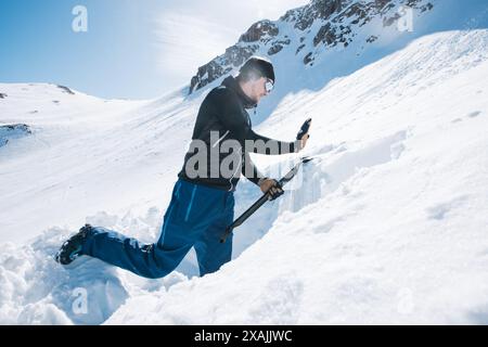 Ein Mann, der ein Schneeprofil für die Lawinenkontrolle auf verschneiten Bergen erstellt Stockfoto