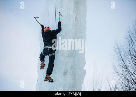 Eiskletterer auf einem gefrorenen Eisturm in Kitzbühel, Tiroler Alpen Stockfoto