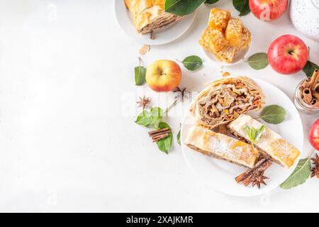 Hausgemachter herbstlicher Apfelstrudel mit karamelisierten Äpfeln, Rosinen, Nüssen, Honig, Zimtgewürzen, auf Teller auf Küchentisch Kopierraum Stockfoto