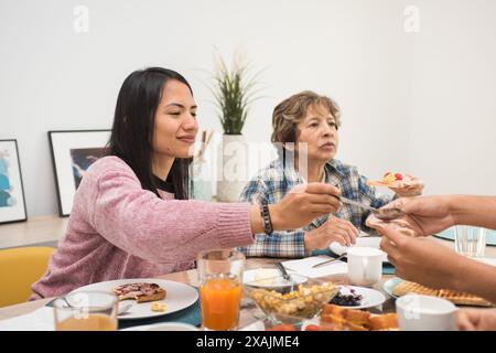 Reife Mutter und kleine Tochter essen zu Hause zusammen frühstücken Stockfoto
