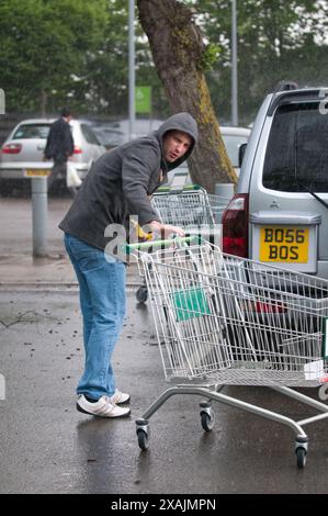 Charlotte Church und ihre Kinder Ruby und Dexter bilden zusammen mit ihrem Freund Jonathan Powell die perfekte Familiengruppe, wenn sie heute in einem Supermarkt in der Nähe ihres Hauses außerhalb von Cardiff einkaufen gehen. Aber was für ein Unterschied ein paar Stunden machen... Sie kamen bei warmem Sonnenschein an und gingen in einem sintflutartigen Regenguss zurück. Stockfoto