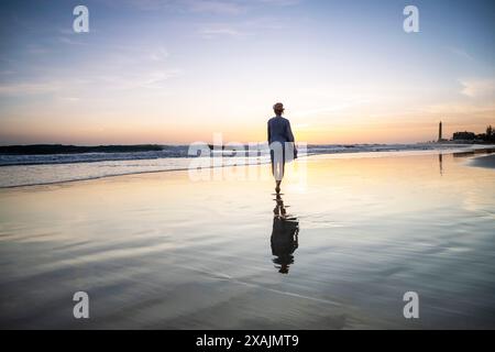 Frau auf einem Abendspaziergang, Maspalomas Leuchtturm bei Sonnenuntergang, Gran Canaria, Spanien Stockfoto