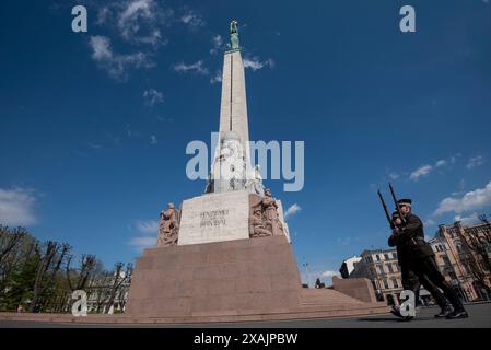 Zwei Soldaten marschieren vor dem Freiheitsdenkmal in Riga. Das Denkmal wurde 1935 geweiht und trägt die Inschrift „für Vaterland und Freiheit“ in Riga, Lettland Stockfoto