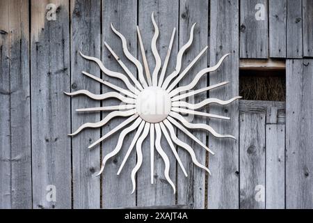 Dielenwand mit Holzsonne. Stockfoto