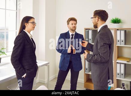 Team aus jungen Geschäftsleuten, die bei einer Arbeitssitzung über ein ernstes Thema diskutieren Stockfoto