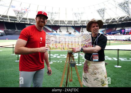 Der KORRIGIERENDE NAME VON BRYCE HARPER AN SPENCER TURNBULL KORRIGIERT DIE BILDUNTERSCHRIFT UNTER Philadelphia Phillies' Spencer Turnbull posiert neben dem Künstler Andy Brown (rechts) während eines Workout-Tages vor dem Spiel der MLB London Series im London Stadium. Bilddatum: Freitag, 7. Juni 2024. Stockfoto