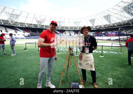 Der KORRIGIERENDE NAME VON BRYCE HARPER AN SPENCER TURNBULL KORRIGIERT DIE BILDUNTERSCHRIFT UNTER Philadelphia Phillies' Spencer Turnbull posiert neben dem Künstler Andy Brown (rechts) während eines Workout-Tages vor dem Spiel der MLB London Series im London Stadium. Bilddatum: Freitag, 7. Juni 2024. Stockfoto