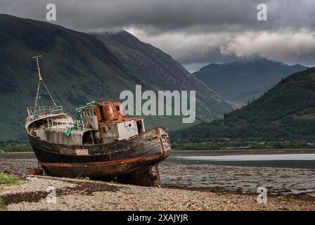 Das Schiffswrack von Corpach lag an der Küste nahe Fort William, Westküste Schottlands, mit nebelbedeckten Bergen im Hintergrund Stockfoto