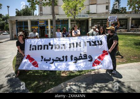 Jerusalem, Israel. Juni 2024. Die Demonstranten halten ein Banner, das ihre Meinung während der Demonstration im Pariser Squire zum Ausdruck bringt. Israelische Friedensaktivisten protestieren in der Nähe des Wohnsitzes des israelischen Premierministers Benjamin Netanjahu und halten Schilder, in denen sie fordern, dass Israel seine Angriffe auf Gaza beendet und israelische Geiseln nach Jerusalem zurückbringt. Quelle: SOPA Images Limited/Alamy Live News Stockfoto