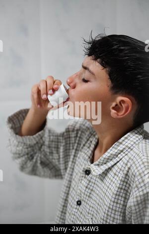 Preteen in ihrer morgendlichen Routine spülte ihren Mund mit Mundwasser, um ihre Zähne zu pflegen Stockfoto