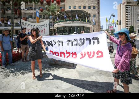 Jerusalem, Israel. Juni 2024. Die Demonstranten halten ein Banner, das ihre Meinung während der Demonstration im Pariser Squire zum Ausdruck bringt. Israelische Friedensaktivisten protestieren in der Nähe des Wohnsitzes des israelischen Premierministers Benjamin Netanjahu und halten Schilder, in denen sie fordern, dass Israel seine Angriffe auf Gaza beendet und israelische Geiseln nach Jerusalem zurückbringt. (Foto: Saeed Qaq/SOPA Images/SIPA USA) Credit: SIPA USA/Alamy Live News Stockfoto