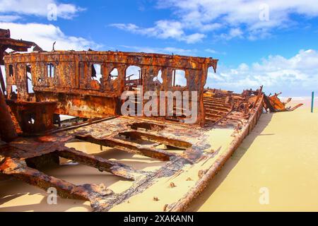 Rostiges, zerbröckelndes Stück des SS Maheno Schiffswracks, halb im Sand des 75 Meilen langen Strandes an der Ostküste von Fraser Island in Queensland, Austra, begraben Stockfoto