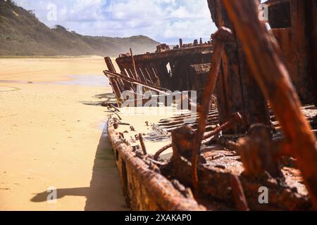 Rostiges, zerbröckelndes Stück des SS Maheno Schiffswracks, halb im Sand des 75 Meilen langen Strandes an der Ostküste von Fraser Island in Queensland, Austra, begraben Stockfoto