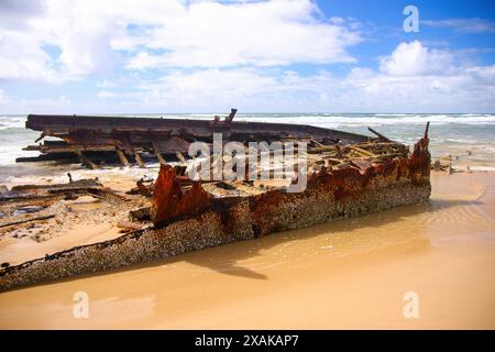 Rostiges, zerbröckelndes Stück des SS Maheno Schiffswracks, halb im Sand des 75 Meilen langen Strandes an der Ostküste von Fraser Island in Queensland, Austra, begraben Stockfoto