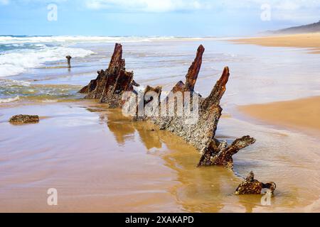 Rostiges, zerbröckelndes Stück des SS Maheno Schiffswracks, halb im Sand des 75 Meilen langen Strandes an der Ostküste von Fraser Island in Queensland, Austra, begraben Stockfoto