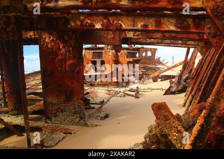 Rostiges, zerbröckelndes Stück des SS Maheno Schiffswracks, halb im Sand des 75 Meilen langen Strandes an der Ostküste von Fraser Island in Queensland, Austra, begraben Stockfoto