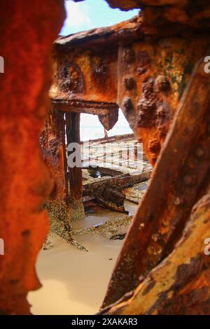 Rostiges, zerbröckelndes Stück des SS Maheno Schiffswracks, halb im Sand des 75 Meilen langen Strandes an der Ostküste von Fraser Island in Queensland, Austra, begraben Stockfoto