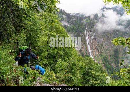 Europa, Deutschland, Bayern, Bayerische Alpen, Berchtesgaden, Bergwanderer auf dem Landtalsteig mit Röthbachfällen im Hintergrund Stockfoto