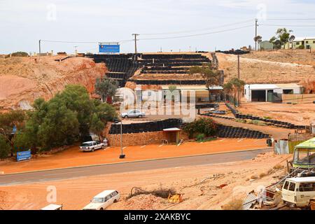 Stützmauer aus Reifen auf einem Hügel, die das unterirdische Comfort Inn der Opal-Bergbaustadt Coober Pedy im Outback von South Australia versteckt Stockfoto