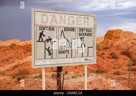 Gefahrenschild vor Toms arbeitender Opal-Mine in Coober Pedy, South Australia - Warnung vor tiefen Minenschächten in der australischen Wüste Stockfoto