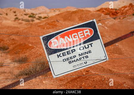 Gefahrenschild vor Toms arbeitender Opal-Mine in Coober Pedy, South Australia - Warnung vor tiefen Minenschächten in der australischen Wüste Stockfoto