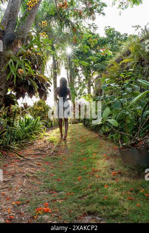 Nordamerika, Karibik, Hispaniola Island, Dominikanische Republik, Samana-Halbinsel, Sanchez, Jardines La Loma, hübsche dunkelhäutige Latina schlendert entlang eines Pfades in tropischer Vegetation Stockfoto