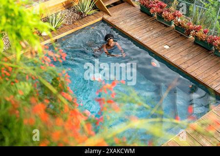 Nordamerika, Karibik, Hispaniola Island, Dominikanische Republik, Samana-Halbinsel, Sanchez, Jardines La Loma, ziemlich dunkelhäutige Latina schwimmt im Pool Stockfoto