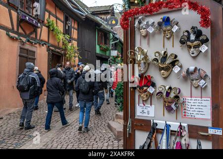 Europa, Frankreich, Grand Est, Elsass, Riquewihr, kaufen Sie mit kunstvollen Masken in einer engen Gasse Stockfoto