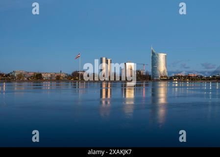 Blick über den Fluss Daugava zum Hauptquartier der Swedbank, mit den Wohntürmen der Zunda Towers und der lettischen Flagge auf der linken Seite, Riga, Lettland Stockfoto