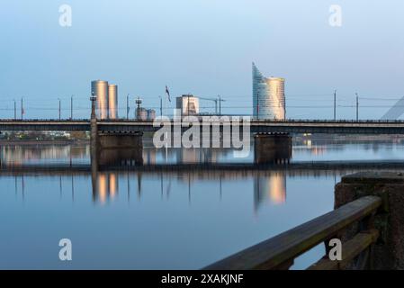 Blick über den Fluss Daugava zum Hauptquartier der Swedbank, mit den Wohntürmen der Zunda Towers und der lettischen Flagge auf der linken Seite, Riga, Lettland Stockfoto