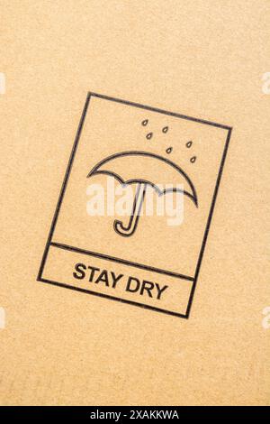 Internationales Symbol für Regenschirm und Regentropfen – Produkte trocken/vor Regen/von Wasser fernhalten. Chinglish „Stay Dry“, Regen stoppte das Spiel, hielt trocken. Stockfoto