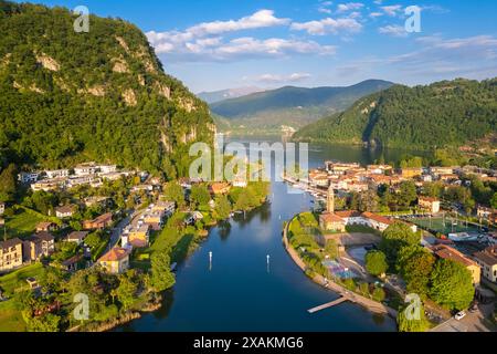Aus der Vogelperspektive auf das kleine italienische Dorf Lavena mit seiner Meerenge bei Sonnenuntergang. Lavena Ponte Tresa, Bezirk Varese, Lombardei, Italien. Stockfoto