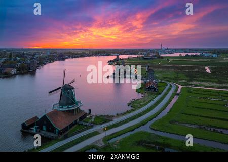 Luftaufnahme der typischen Windmühlen von Zaanse Schans auf dem Fluss Zaan im Frühling. Zaanse Schans, Nordholland, Gemeinde Zaanstad, Niederlande, Europa. Stockfoto