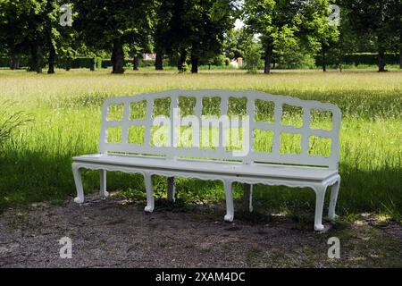 Weiße Holzbank im Park rund um das Schloss Schleissheim im Dorf Oberschleissheim, Vorort München, Bayern. Stockfoto