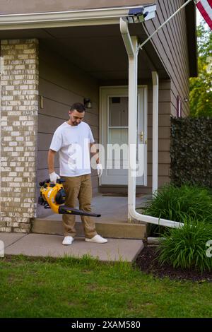 Gartenarbeiter saugt Blätter vom Hof und von der Treppe ab Stockfoto