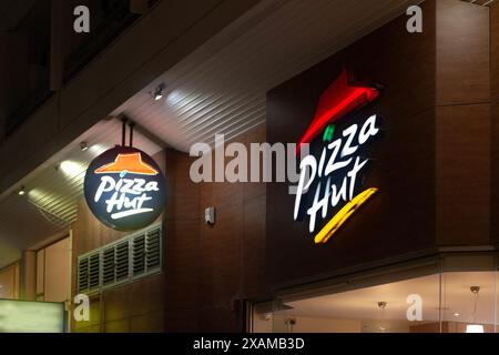 Larnaca, Zypern - 03. Februar 2024: Beleuchtete Schilder in der Nacht von Pizza Hut, einer multinationalen amerikanischen Pizzeria-Kette. Stockfoto