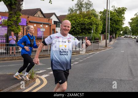 Leeds, Großbritannien. JUNI 2024. Der Läufer posiert vor der Kamera, während er an einer 7-Meilen-Route teilnimmt, die wie ein Nashorn geformt ist, durch die Straßen von Moor Town zu Ehren von Leeds Rhinos-Legende Nummer 7 Rob Burrow, der am Sonntag im Alter von 41 Jahren nach einem über 4-jährigen Kampf gegen die Motoneurone Disease (MND) starb. Credit Milo Chandler/Alamy Live News Stockfoto