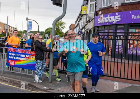 Leeds, Großbritannien. JUNI 2024. Läufer posieren vor der Kamera, während sie an einer 7-Meilen-Route teilnehmen, die wie ein Nashorn geformt ist, durch die Straßen von Moor Town zu Ehren von Leeds Rhinos-Legende Nummer 7 Rob Burrow, der am Sonntag im Alter von 41 Jahren nach einem über vierjährigen Kampf gegen die Motoneurone Disease (MND) starb. Credit Milo Chandler/Alamy Live News Stockfoto