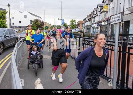 Leeds, Großbritannien. JUNI 2024. Läufer posieren vor der Kamera, während sie an einer 7-Meilen-Route teilnehmen, die wie ein Nashorn geformt ist, durch die Straßen von Moor Town zu Ehren von Leeds Rhinos-Legende Nummer 7 Rob Burrow, der am Sonntag im Alter von 41 Jahren nach einem über vierjährigen Kampf gegen die Motoneurone Disease (MND) starb. Credit Milo Chandler/Alamy Live News Stockfoto