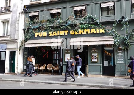 Leute gehen vorbei am PUB St GERMAIN, einem raffinierten Gastro-Pub mit ganztägigem Service, in einem grünen Gebäude in Paris, Frankreich. Stockfoto