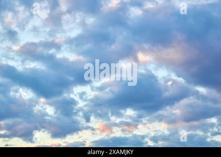 Ein faszinierendes Fragment des Himmels, eine natürliche Kulisse mit bunten Wolken mit faszinierenden Formen, die von der untergehenden Sonne beleuchtet werden, schaffen einen Stockfoto