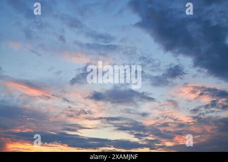 Ein faszinierendes Fragment des Himmels, eine natürliche Kulisse mit bunten Wolken mit faszinierenden Formen, die von der untergehenden Sonne beleuchtet werden, schaffen einen Stockfoto